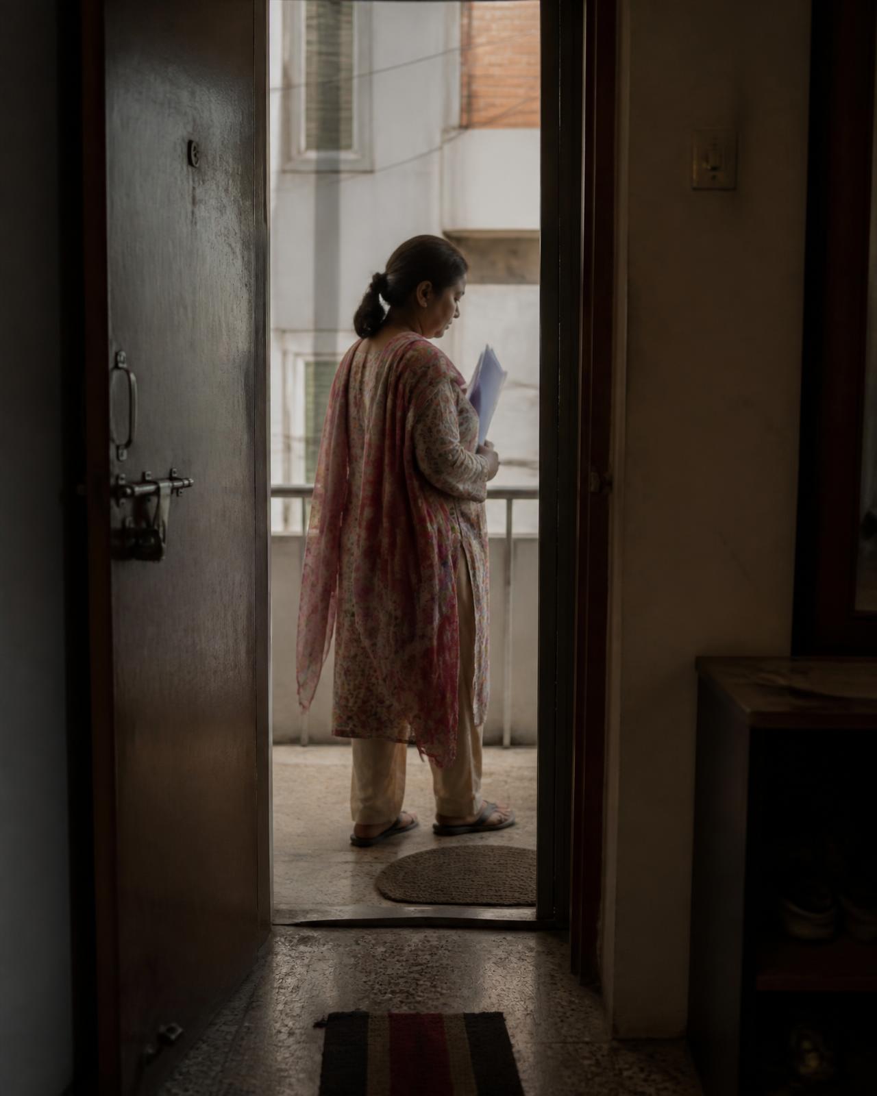 A Nawa representative standing at an apartment doorway holding documents